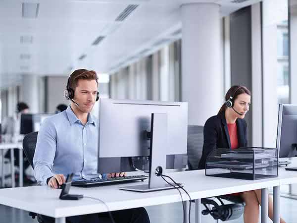 2 Arbeitskollegen sitzen an einem Schreibtisch in einem Büro